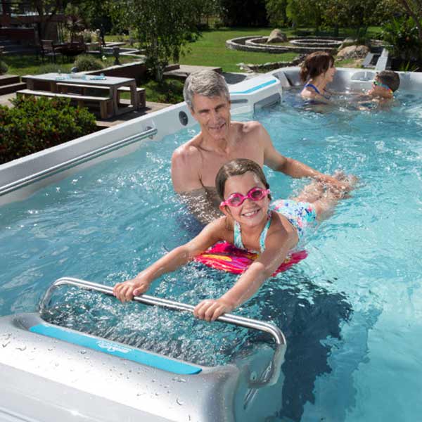 Father and daughter swimming in swim spa in Redding, CA